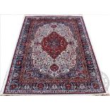A Kashmir rug, worked with a central red floral medallion, set against an ivory ground,