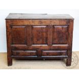 An early 18th century oak mule chest, with triple panelled front and two drawers on stile legs,