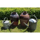 Two stone ware vessels, two galvanised vintage watering cans, with two stone ware crock pots,