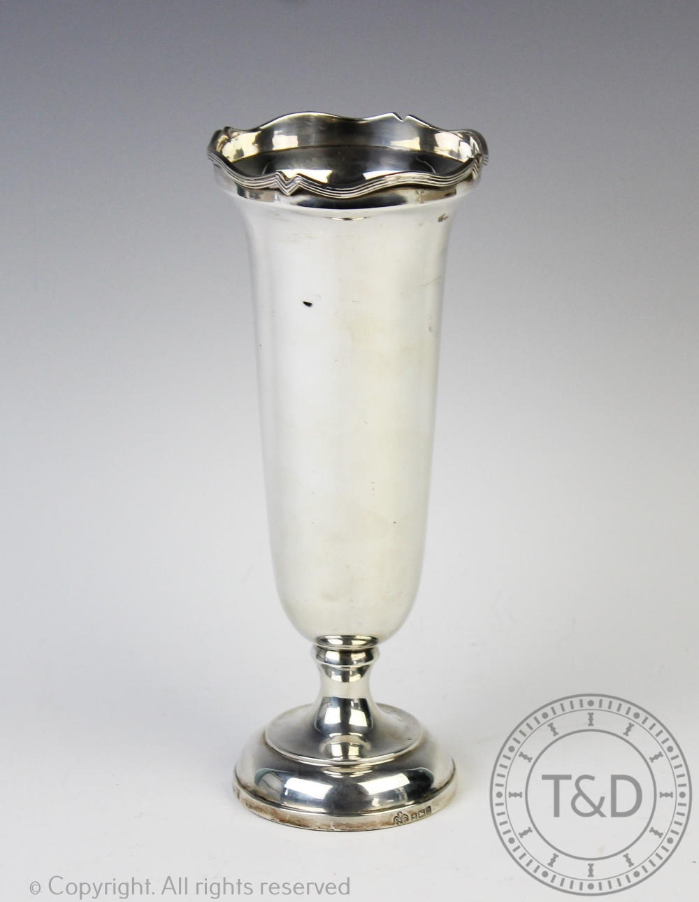 A silver vase, Elkington & Co, Birmingham 1965, of plain polished form with cusped and reeded rim,