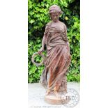 A Victorian style cast iron garden figure, of a muse holding a laurel wreath,