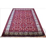 A Kashmir carpet, worked with an all over floral design against a red ground,
