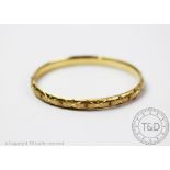 A yellow gold bangle, the hinged bangle stamped '14k', with facteted decoration throughout,