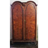 A Queen Anne style double dome top wardrobe, with two doors, on cabriole legs,