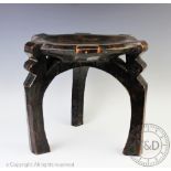 An East African Tanzanian HeHe tribe carved wood stool, with dished seat, on three legs,