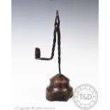 An 18th century wrought iron rush light, with twist detailing on tuned wooden base,