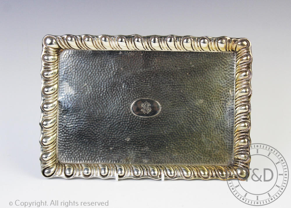 A silver dressing table tray, Birmingham 1907, with gadrooned rim and hammered finish,