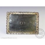 A silver dressing table tray, Birmingham 1907, with gadrooned rim and hammered finish,