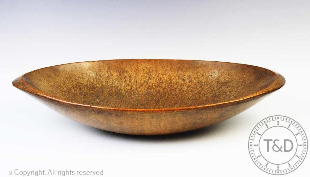 A 19th century vernacular treen sycamore oval settling bowl, 58cm wide Provenance: Clynog Farmhouse,