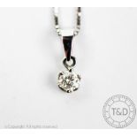 A diamond set pendant, the solitaire pendant set in white gold, claw set, stamped '750',