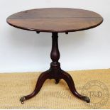 A Regency mahogany tilt top occasional table, with circular top, on a turned column and tripod base,