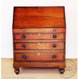 An early 19th century oak and mahogany cross banded bureau, with fall enclosing a fitted interior,