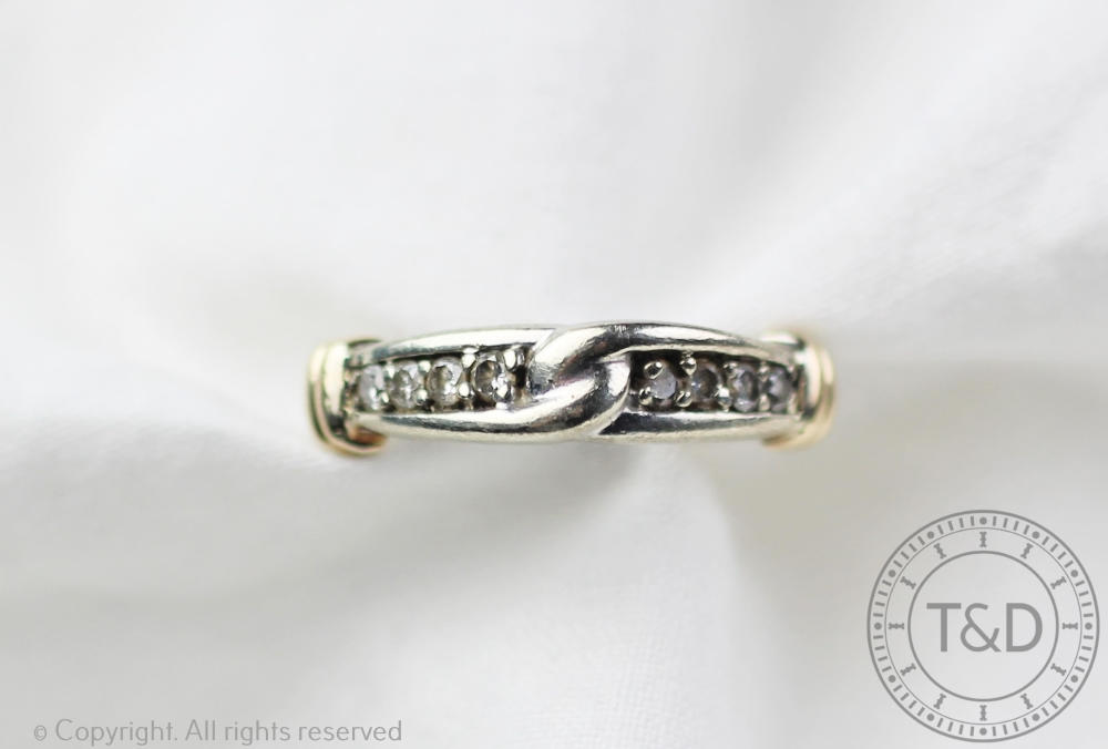 An 9ct gold diamond set eternity ring with 'knot' detail, designed as eight diamonds,