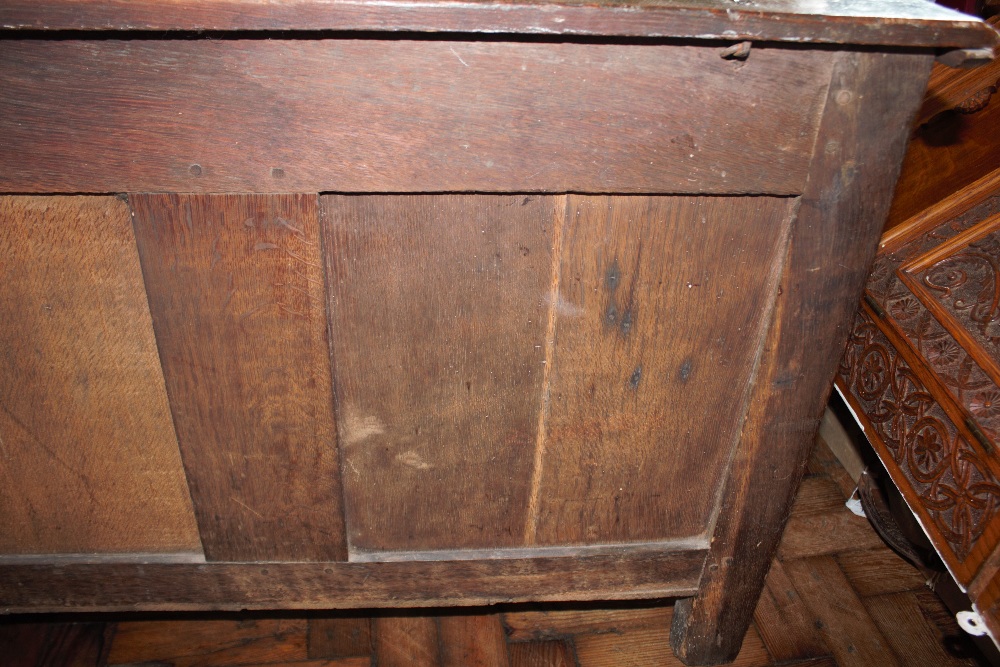 An 18th century oak coffer, with carved and panelled front, on stile legs, - Image 12 of 12