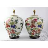 A pair of modern ceramic lamps, decorated with different fruits,