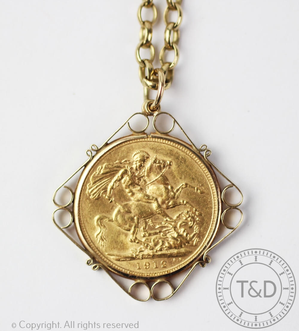 A George V 1912 full sovereign, within 9ct gold mould and attached chain stamped '9ct', 22.