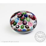 A Clichy scattered canopy paperweight, decorated with a singular clichy rose and ruffle cog blooms,