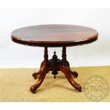 A Victorian walnut oval loo table, of small proportions, with turned columns, on scroll legs,