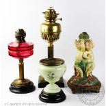 A 19th century Majolica style lamp base, modelled as three cherubs, on gilt metal base, (at fault),