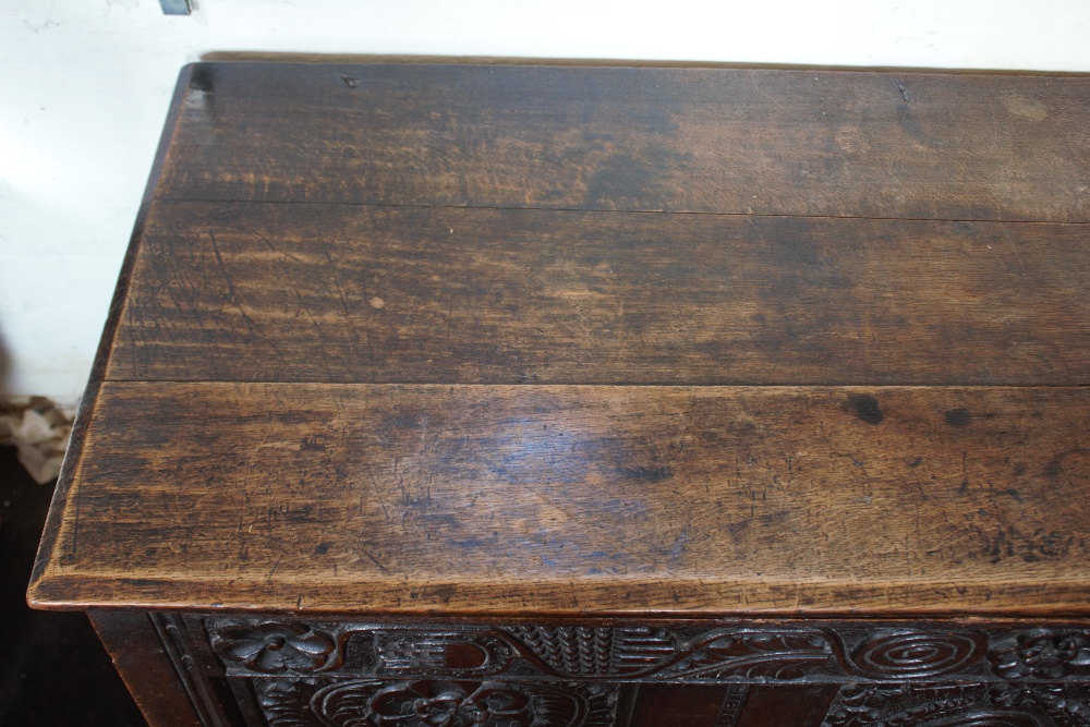 An 18th century oak coffer, with carved and panelled front, on stile legs, - Image 2 of 12