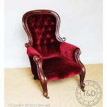 A Victorian carved mahogany scroll frame salon chair, with button back red upholstery,