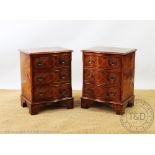 A pair of reproduction serpentine burr walnut bedside chests, with three long drawers,