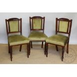 A set of six late Victorian walnut dining chairs, with green upholstery, on turned legs,