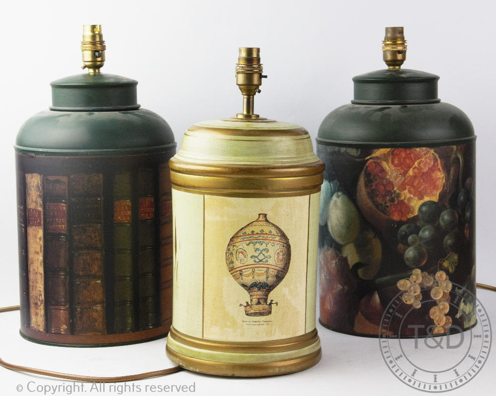 Three modern toleware type lamp bases, one decorated with antiquarian book spines,