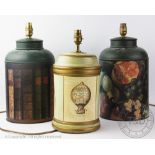 Three modern toleware type lamp bases, one decorated with antiquarian book spines,