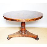 A William IV mahogany circular breakfast table, with turned column on a platform and scroll legs,