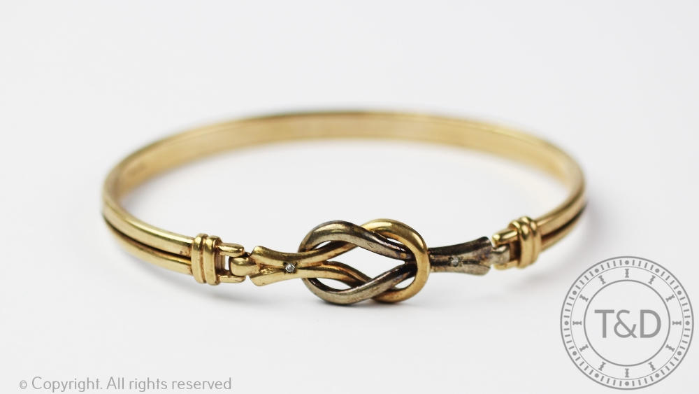 A 9ct bi-colour gold bangle, of entwined knot form, gross weight 8.