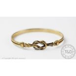 A 9ct bi-colour gold bangle, of entwined knot form, gross weight 8.