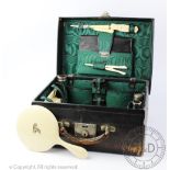 An Edwardian travelling dressing case, enclosing assorted ivorine dressing accessories including,