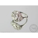 A diamond set cluster ring, designed as a central old cut diamond, millegrain collet set,