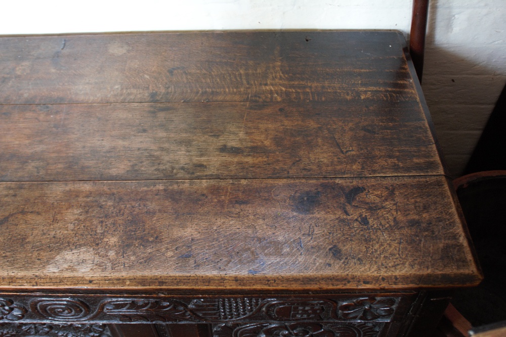 An 18th century oak coffer, with carved and panelled front, on stile legs, - Image 3 of 12