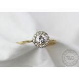 A diamond set daisy cluster ring, the central old brilliant cut diamond,