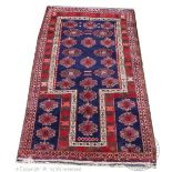 A Caucasian wool prayer mat, worked with flower heads against a blue ground,