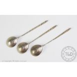 A set of three Russian silver spoons, 19th century, with twisted stems and urn finials,