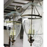 A pair of bell shaped glass hall lanterns, with brass mounts,