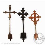 Three Ethiopian iron hand crosses, two decorated with circular motifs,