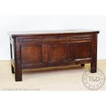 An early 18th century oak coffer, with panelled top and front, on stile feet,