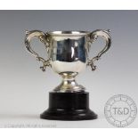 A silver two handled trophy, Adie Brothers Ltd, Birmingham 1937, with scroll handles, on socle base,