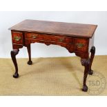 A George II style walnut writing table, with quarter veneered top above three drawers,