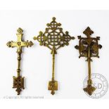 Three Ethiopian brass hand crosses, each with engraved and pierced detailing, 30cm & 26cm & 26.