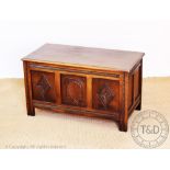 A reproduction oak coffer, with panelled fronts and sides, on stile feet, 50cm H x 89.