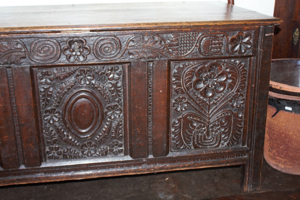 An 18th century oak coffer, with carved and panelled front, on stile legs, - Image 10 of 12