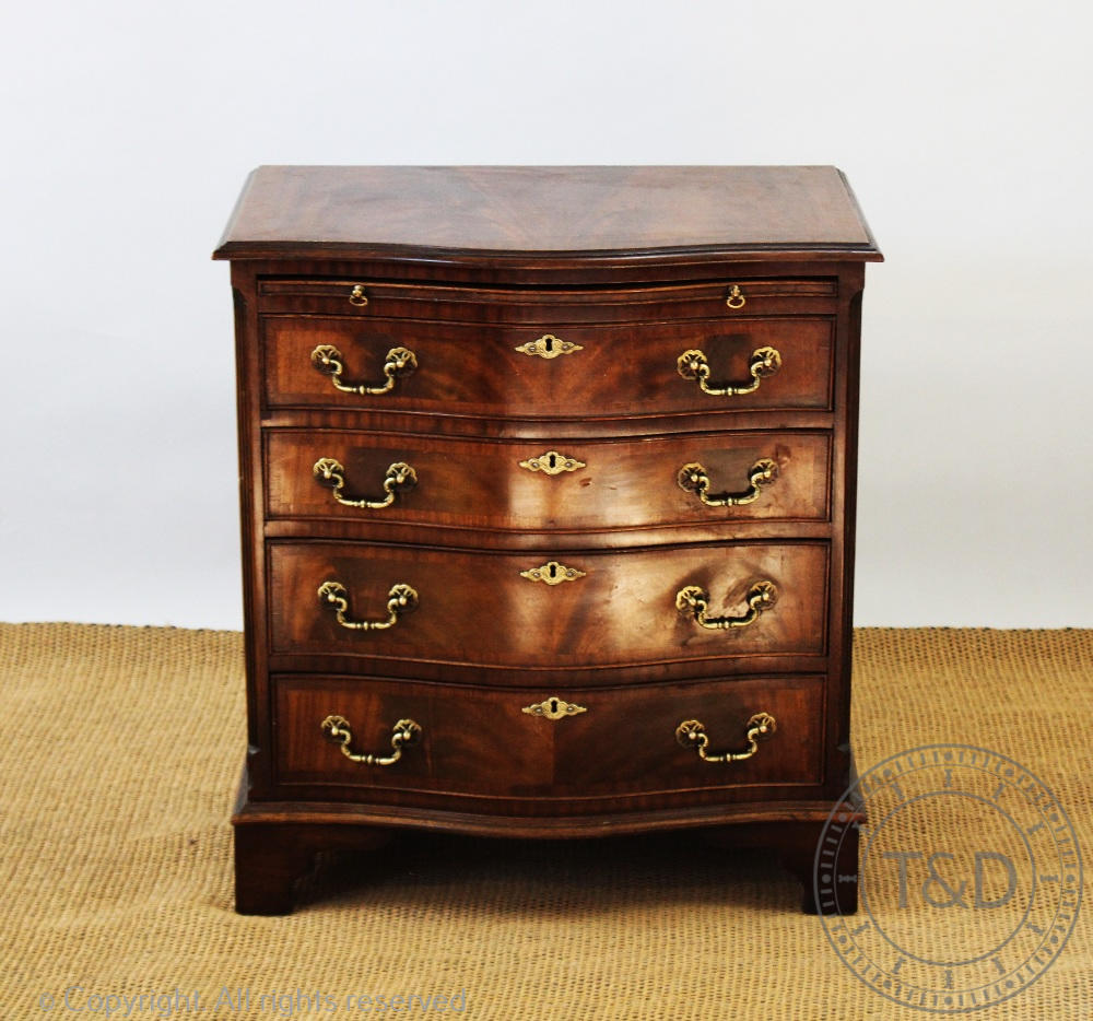 A George III style serpentine mahogany chest, with brush slide and four graduated long drawers,