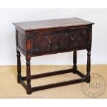 A 1920's oak side table, with two cupboard doors, on square legs and block feet,