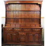 A George III style golden oak dresser, three open shelves and seven small drawers,