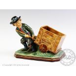 A late 19th century French majolica style novelty match holder, modelled as a boy pulling a cart,